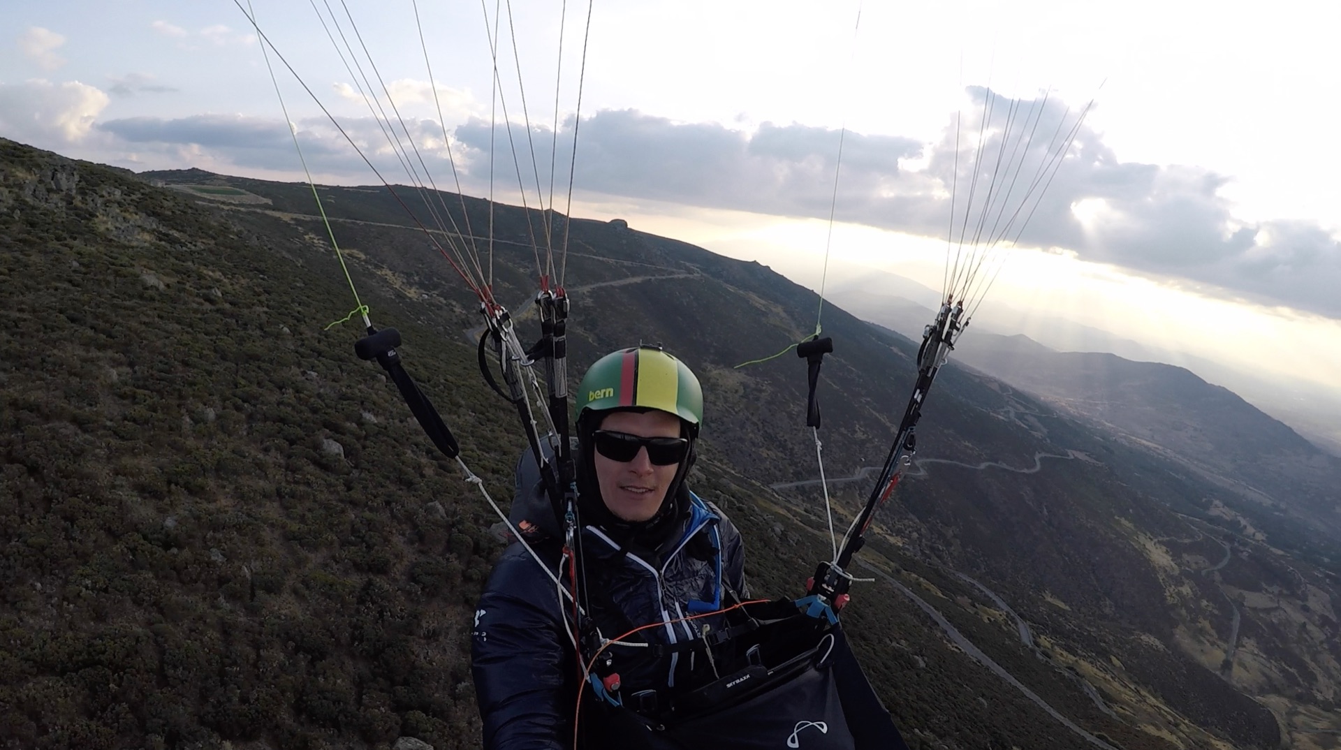 Simon Schnittker im Soloflug über einer Bergkette bei dramatischen Wolken